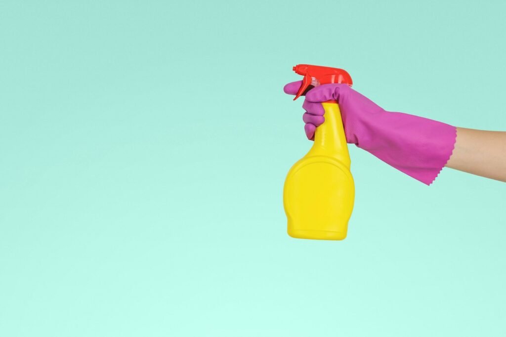 Cleaner holding a spray bottle